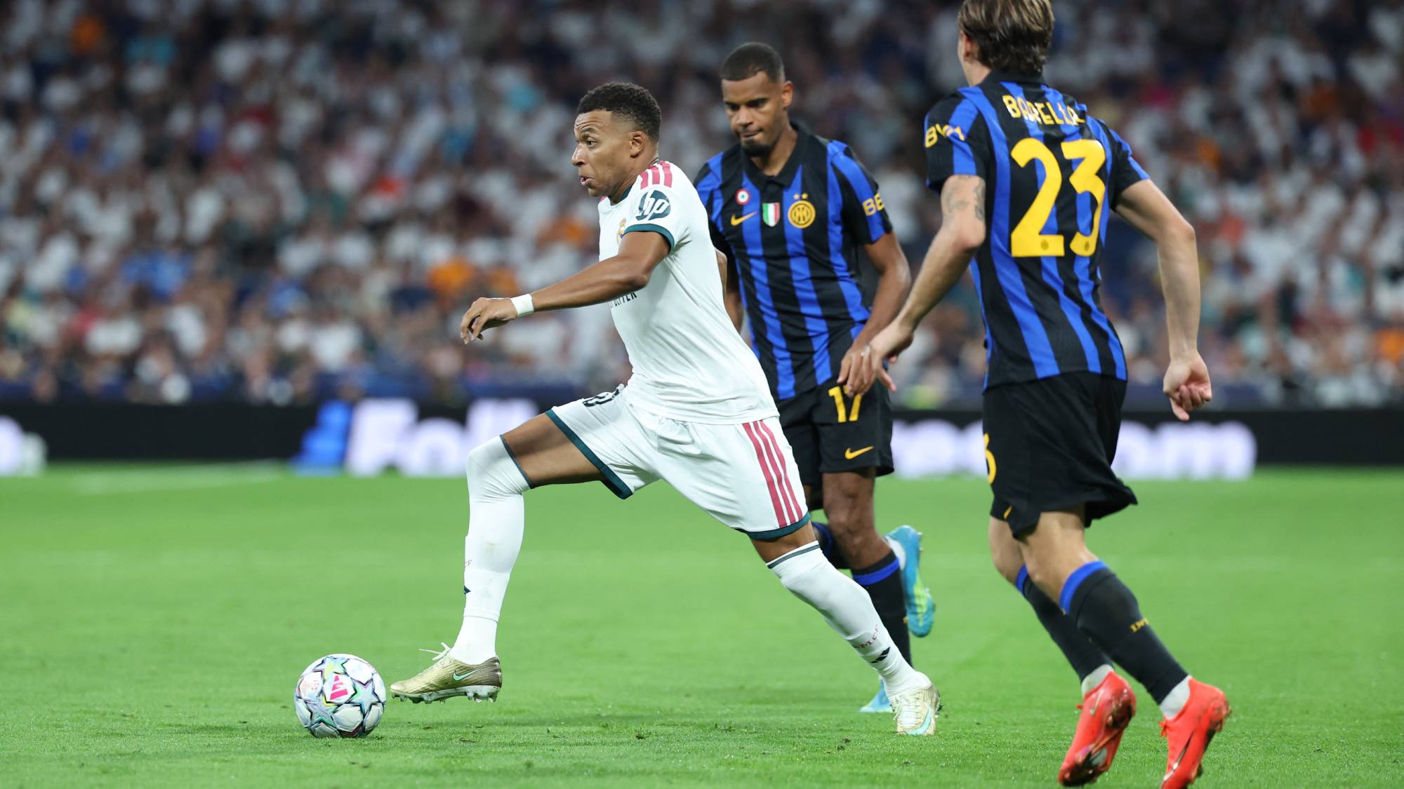 Real Madrid's French forward #10 Kylian Mbappe (L) runs with the ball past Inter Milan's Italian midfielder #23 Nicolo Barella (R) and Inter Milan's French midfielder #17 Andy Diouf during the UEFA Champions League first round day 1 football match between Real Madrid and Inter Milan at the Santiago Bernabeu stadium in Madrid on September 8, 2026.